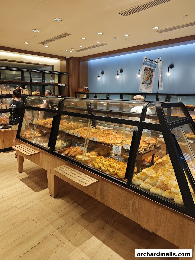 Interior view of a bakery with display cases filled with various pastries and breads.