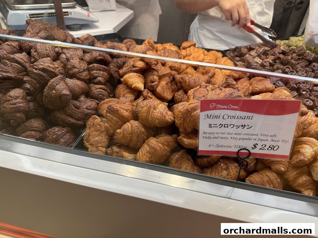 A display of freshly baked mini croissants, some plain and some chocolate flavored.