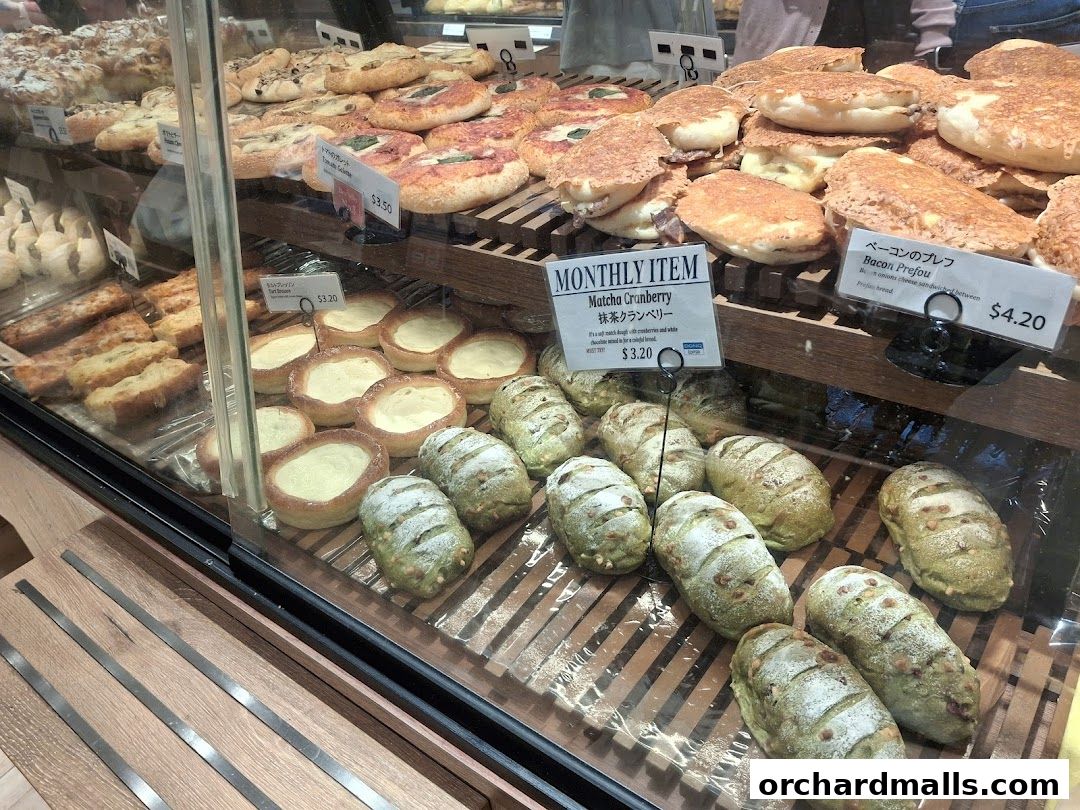 A display case filled with various baked goods, including bread, pastries, and tarts.