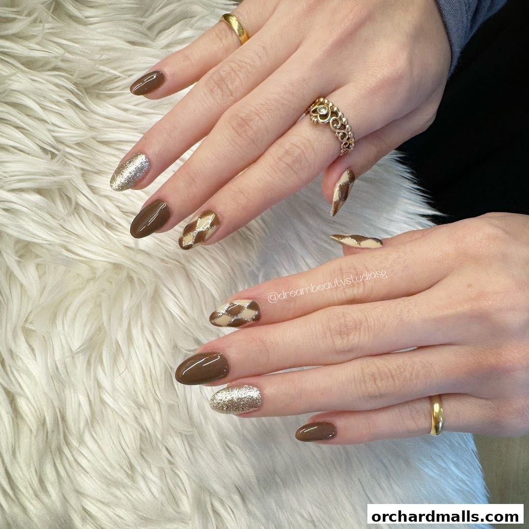 Close-up of hands with stylish brown and gold checkered nail art.