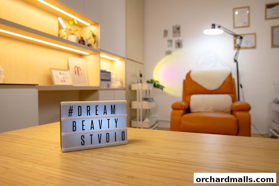 A lit sign with '#DREAM BEAUTY STUDIO' sits on a wooden table in a beauty studio.