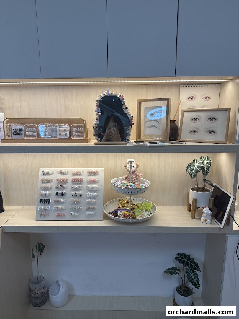 Display shelves showcasing various nail art designs, decorative items, and plants.
