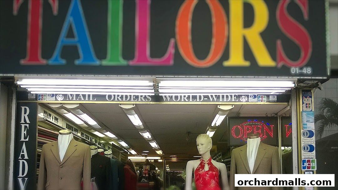 A tailor shop with colorful 'TAILORS' sign, mannequins displaying suits, and an 'OPEN' sign.