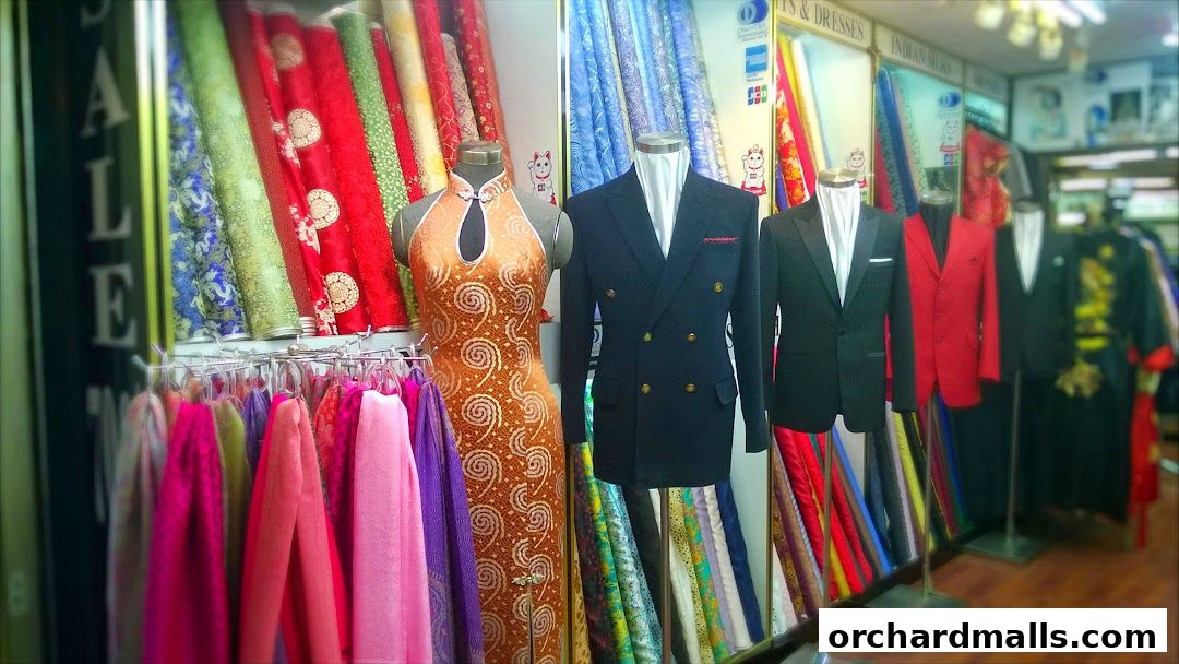 Shop interior with mannequins displaying formal wear and colorful fabrics.