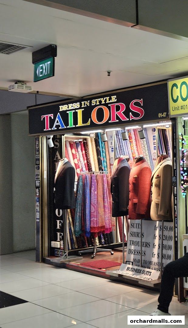 A tailor shop called Dress In Style, showcasing fabrics and tailored suits.