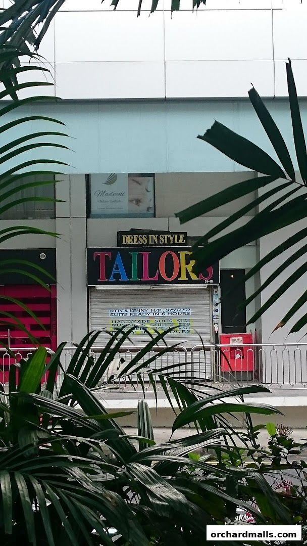A tailor shop named 'Dress In Style' with colorful lettering and services listed.