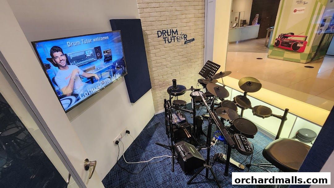 A drum set and a screen displaying a drum tutor welcome message.