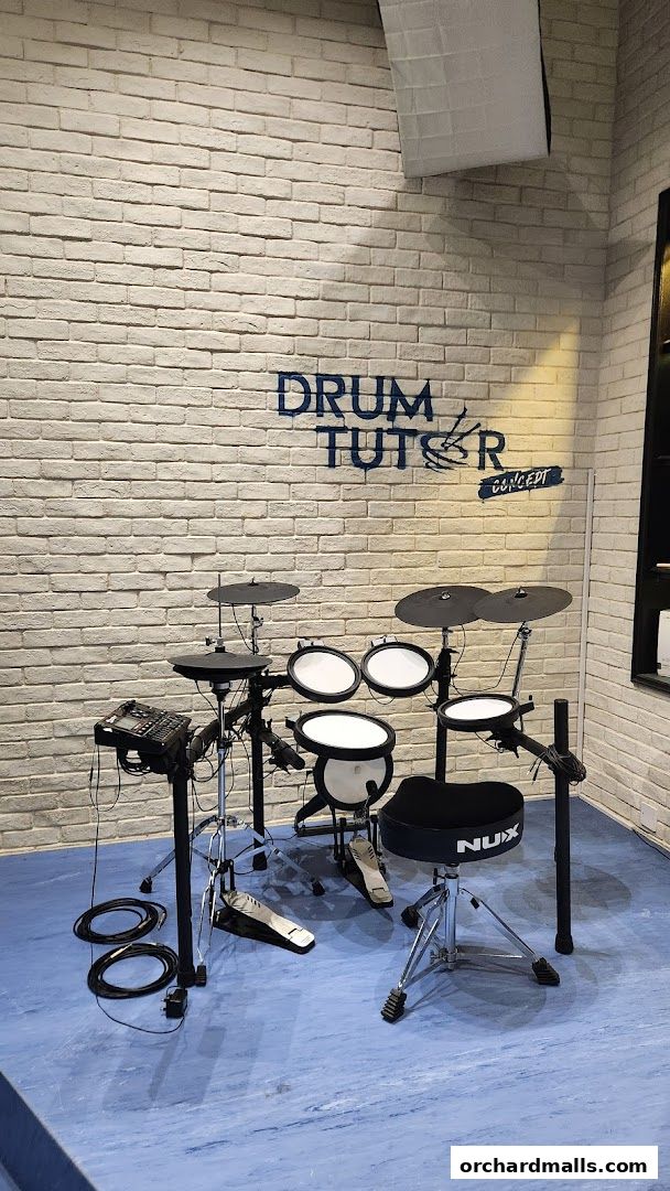 An electronic drum kit set up in a room with a brick wall and blue floor.