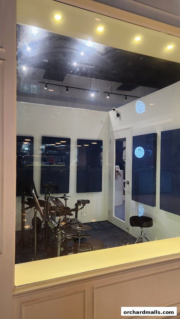 Interior view of a drum lesson studio with electronic drum kit and acoustic panels.