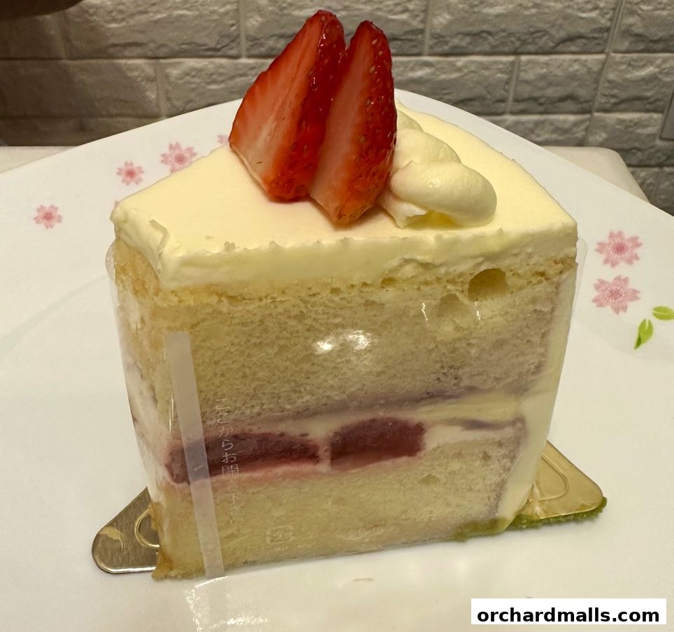 A slice of strawberry shortcake with fresh strawberries and cream on a decorative plate.