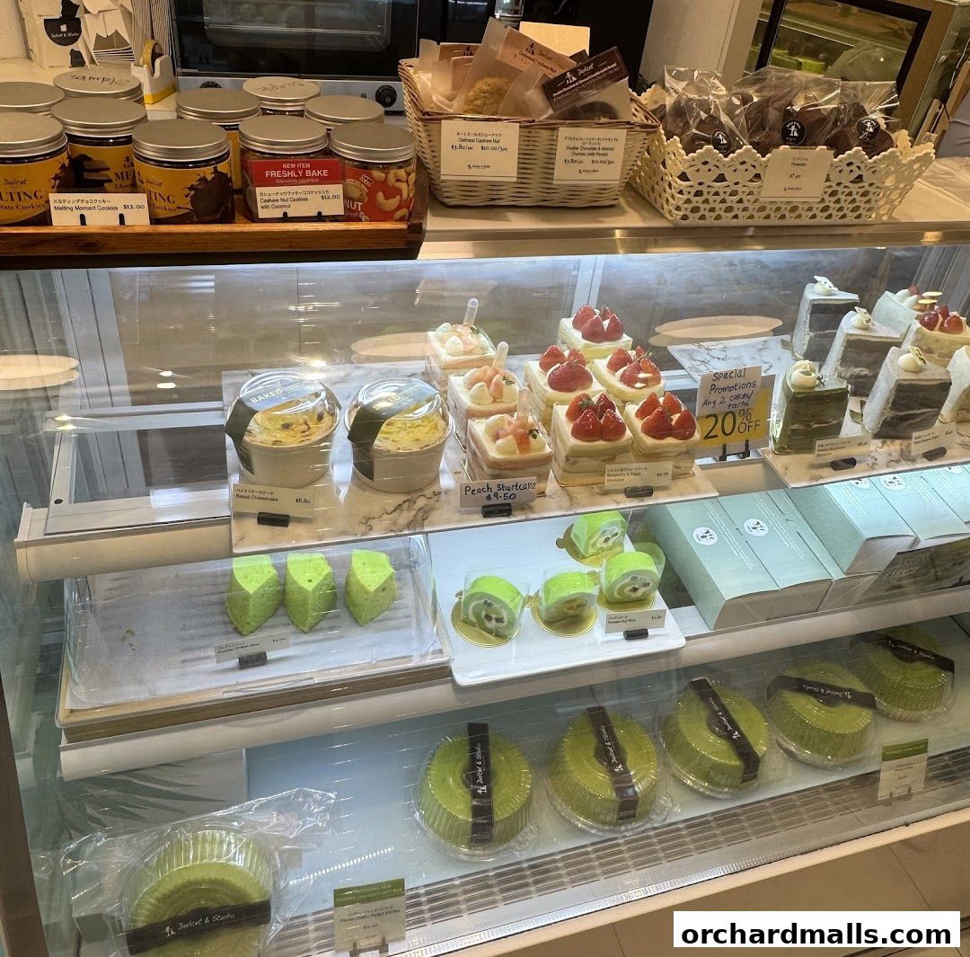 A display case filled with various cakes, pastries, and cookies from Dulcet Studio.