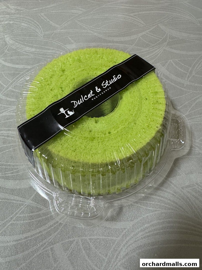 A bright green chiffon cake from Dulcet & Studio in clear packaging.