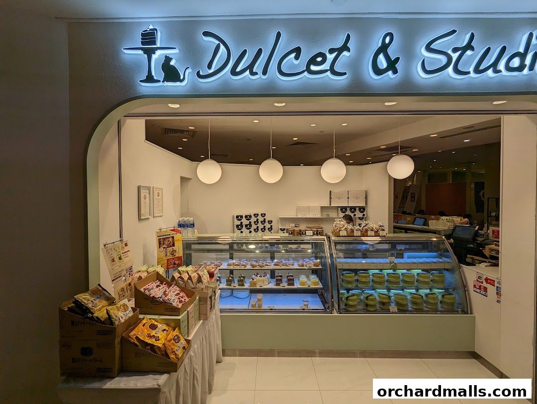 The inviting storefront of Dulcet & Studio, showcasing a display of pastries and cakes.