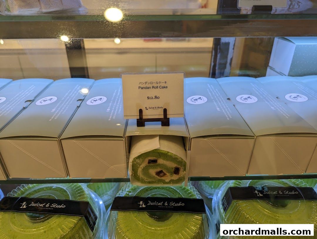 A display case filled with Pandan Roll Cakes and packaged cakes from Dulcet & Studio.