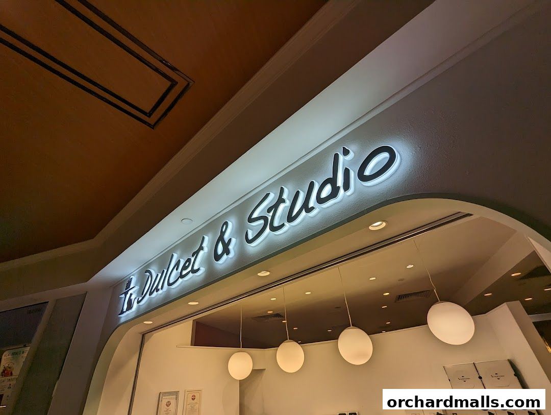 The illuminated sign for 'Dulcet & Studio' above a shop entrance.