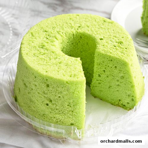 A light green chiffon cake with a slice removed, presented in clear packaging.