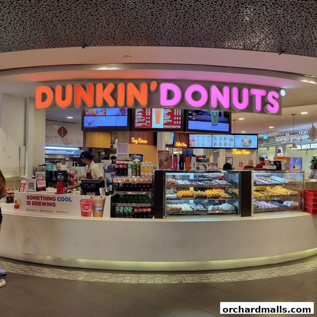 The Dunkin' Donuts shop front displays a variety of donuts and beverages, with staff serving customers.