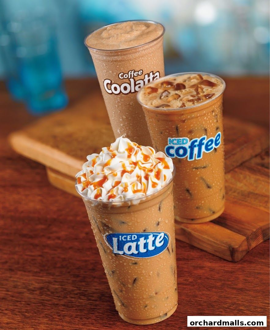 Three iced coffee drinks from Dunkin' are displayed on a wooden surface.
