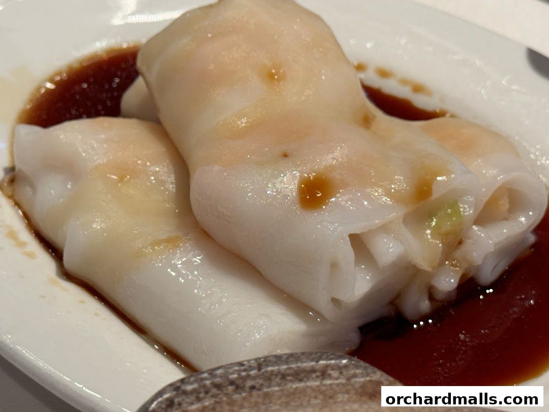 Close-up of delicious steamed rice noodle rolls with savory sauce.