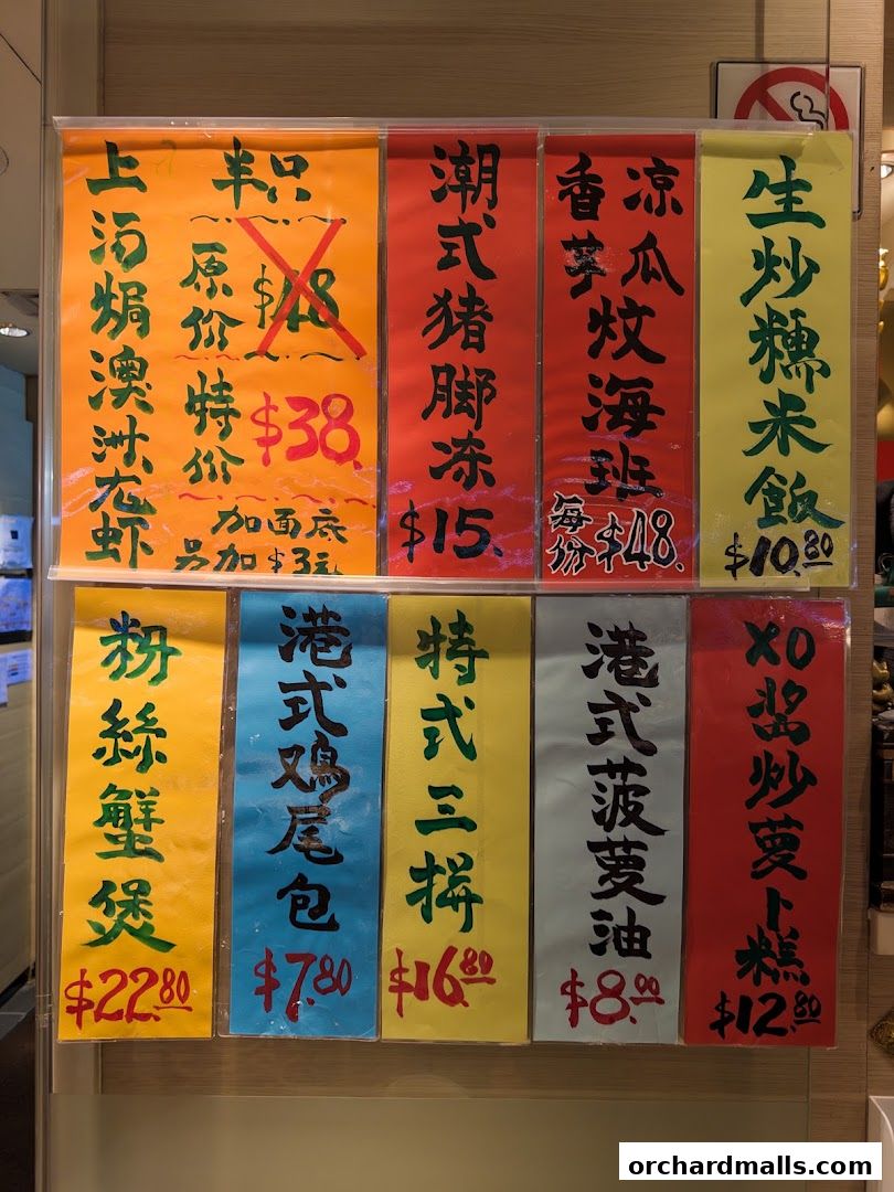 A colorful display of various Chinese food items with prices listed on signs.