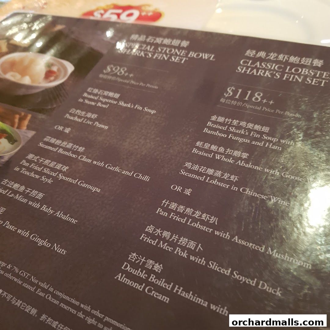 A close-up of a restaurant menu featuring seafood and shark fin sets with prices.