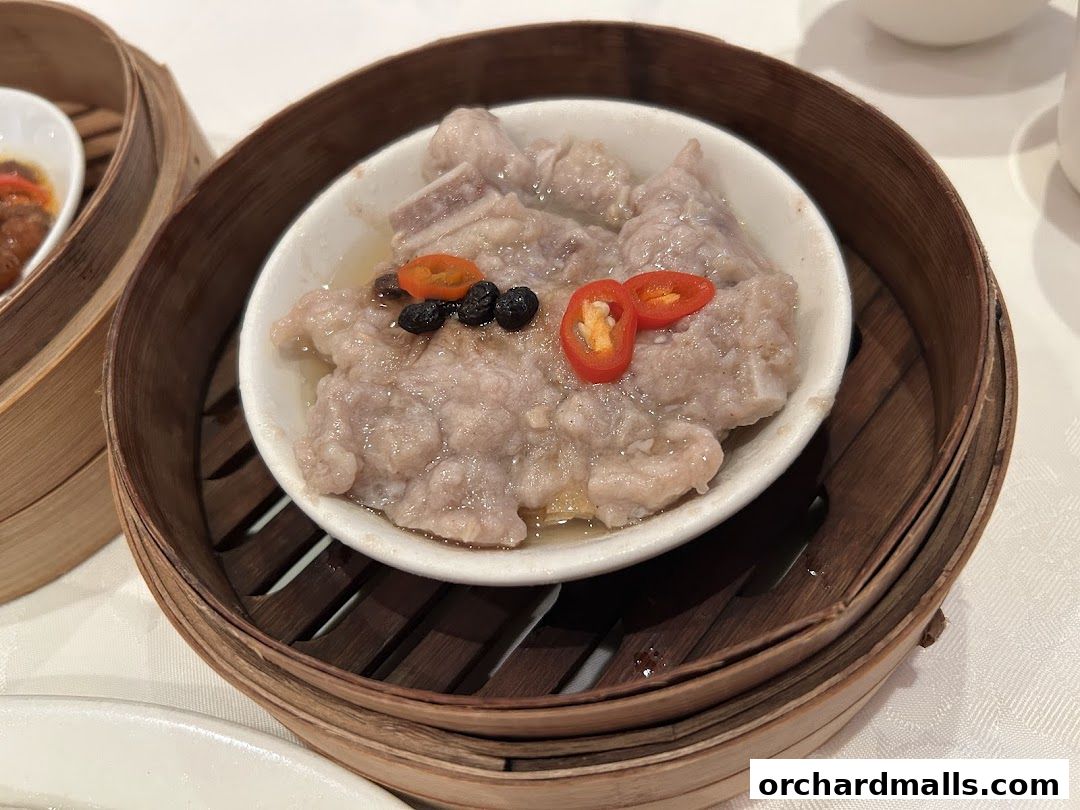 Steamed pork ribs with chili and black beans in a bamboo steamer.