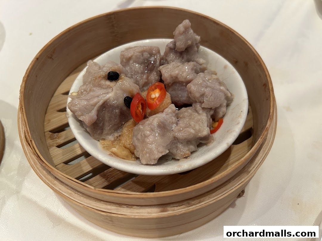 Steamed pork ribs with black beans and chili in a bamboo steamer.
