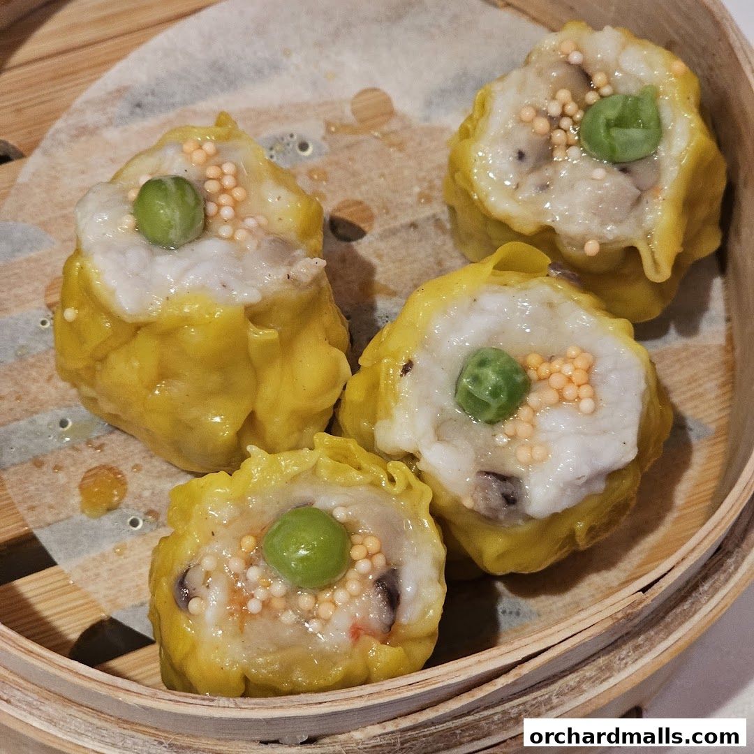 Close-up of four delicious dim sum dumplings in a bamboo steamer.