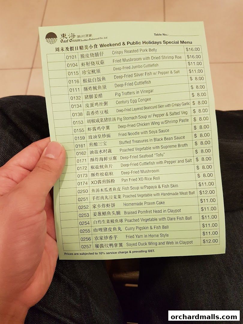 A hand holds a special weekend and public holidays menu from East Ocean Restaurant.
