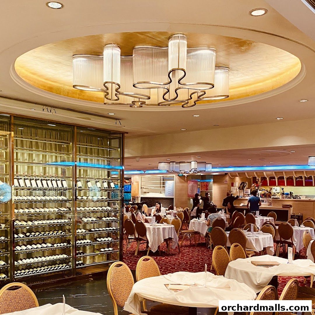 Interior of East Ocean Restaurant with tables, chairs, and a large wine display.