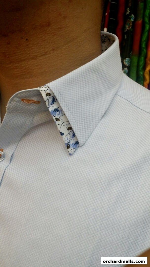 Close-up of a light blue textured dress shirt with a floral patterned collar.