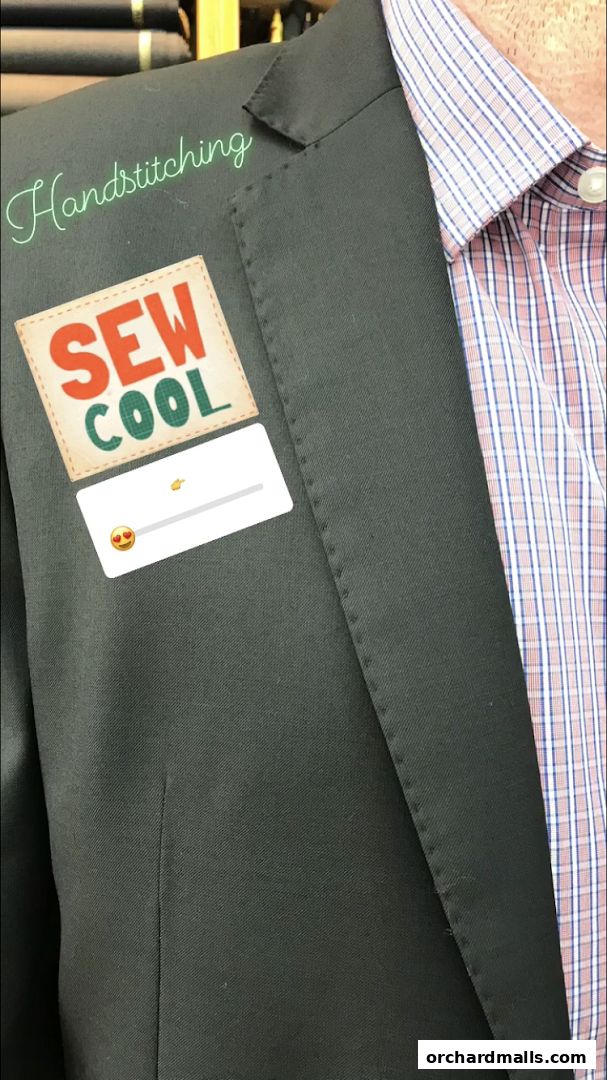 A close-up of a dark suit jacket with a plaid shirt, featuring a 'Sew Cool' patch and 'Handstitching' text.