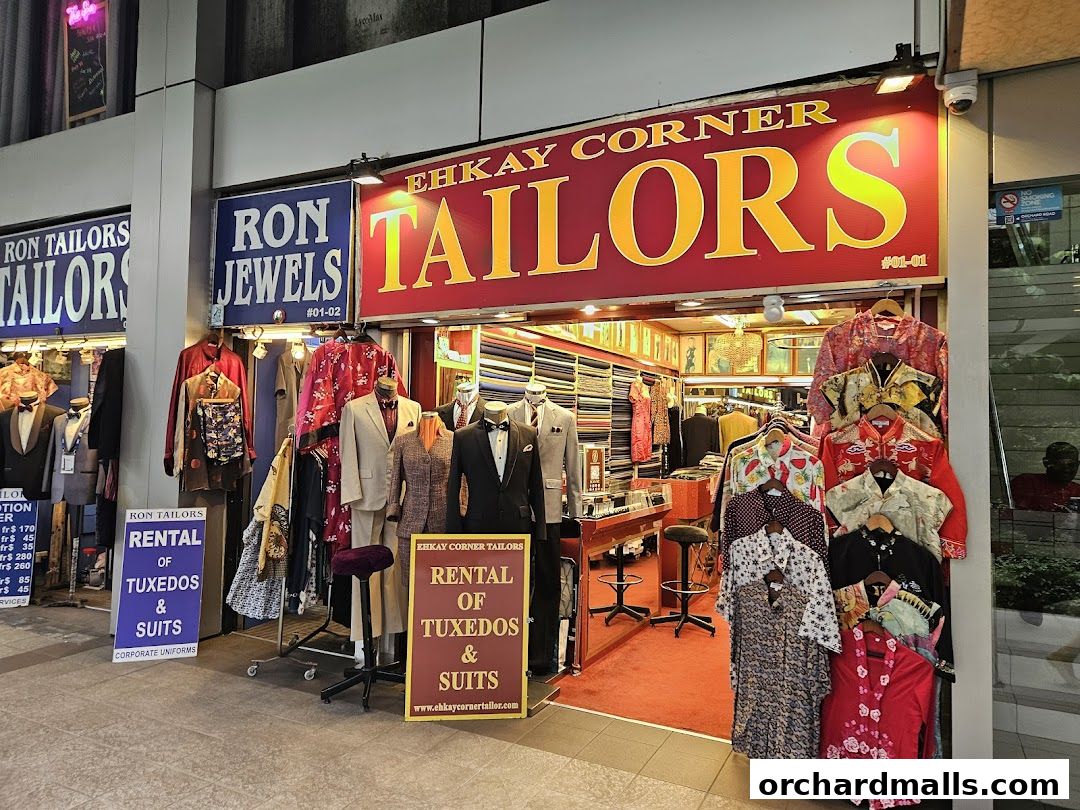 Ehkay Corner Tailors shop front displaying suits, shirts, and rental services for tuxedos.