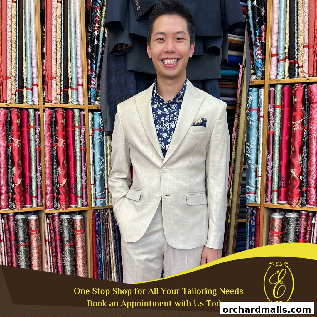 A man in a tailored suit stands in front of shelves filled with colorful fabrics.