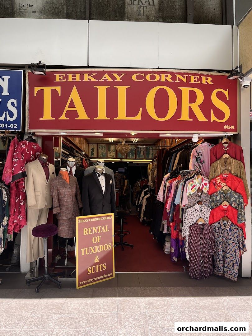 Exterior of Ehkay Corner Tailors shop, showcasing suits, tuxedos, and various garments.