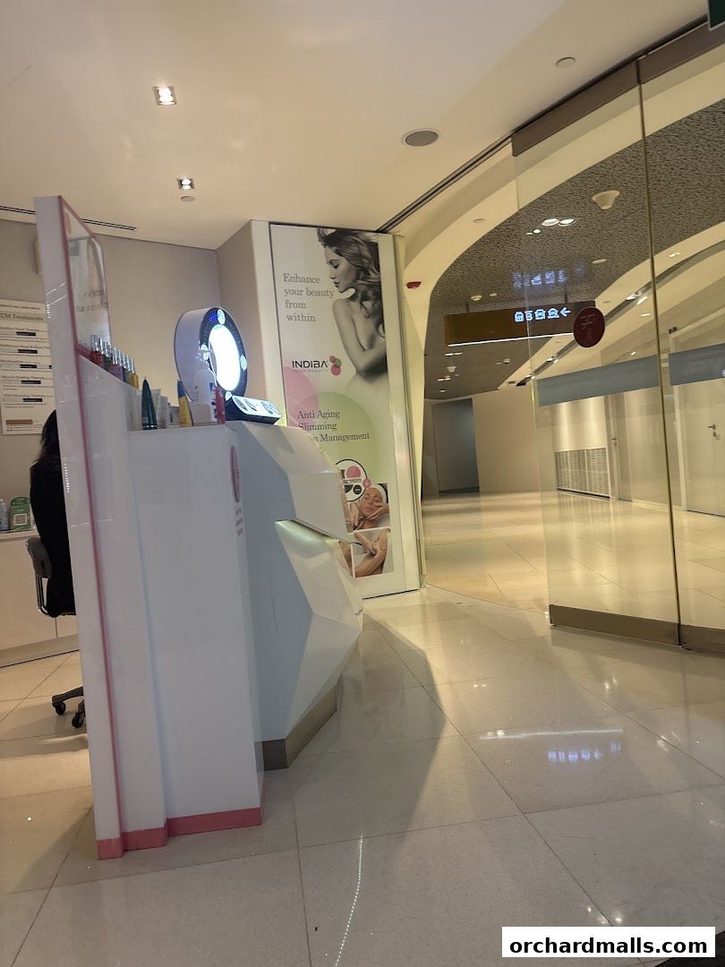 A reception desk with beauty products and a promotional poster for INDIBA.