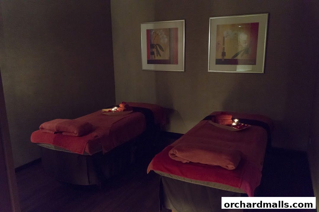 Two massage beds are set up in a dimly lit room with artwork on the walls.