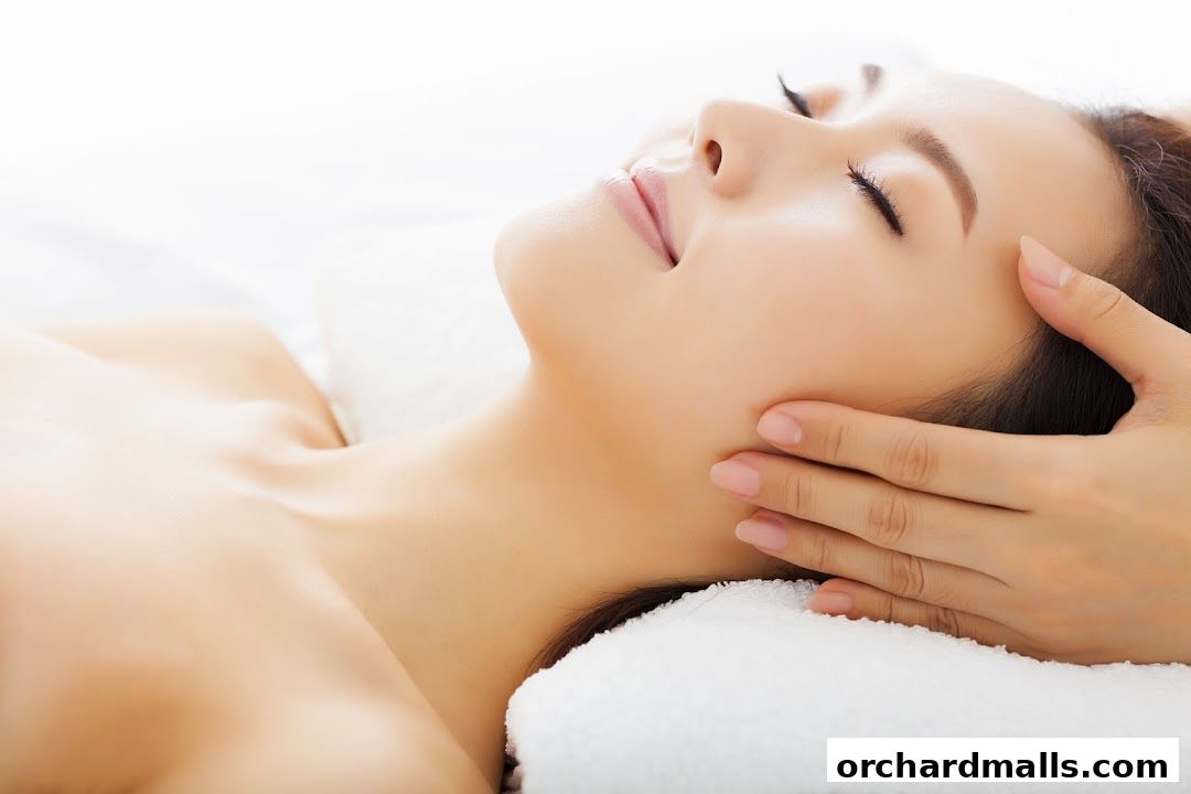 A serene close-up of a woman receiving a facial massage, eyes closed in relaxation.