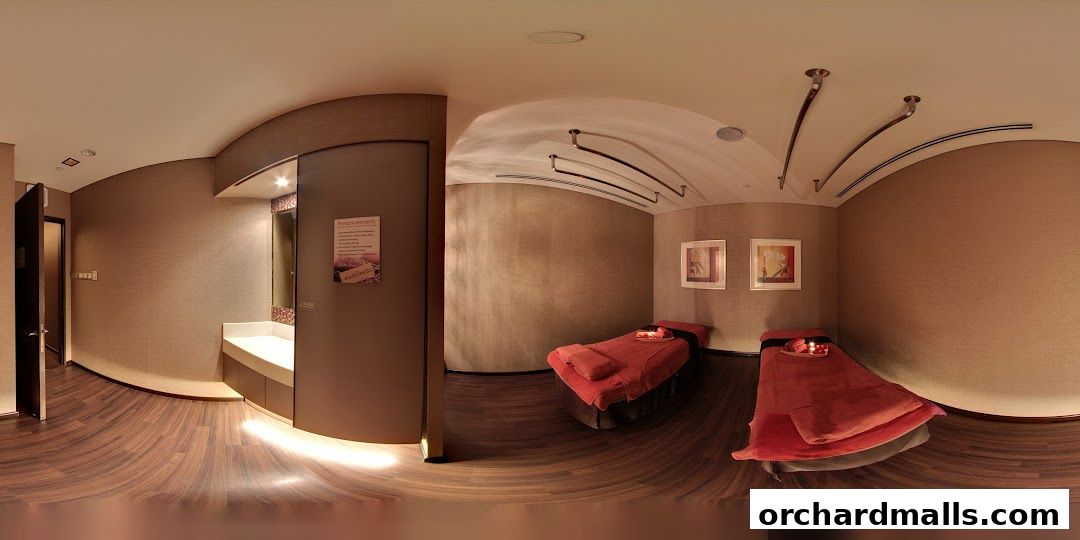 A serene spa room with two massage beds, a vanity area, and calming decor.