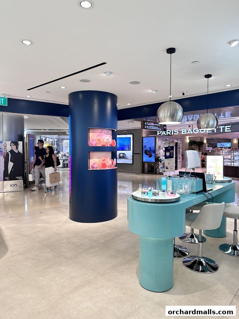 Elemis London shop display with skincare products and seating in a mall.