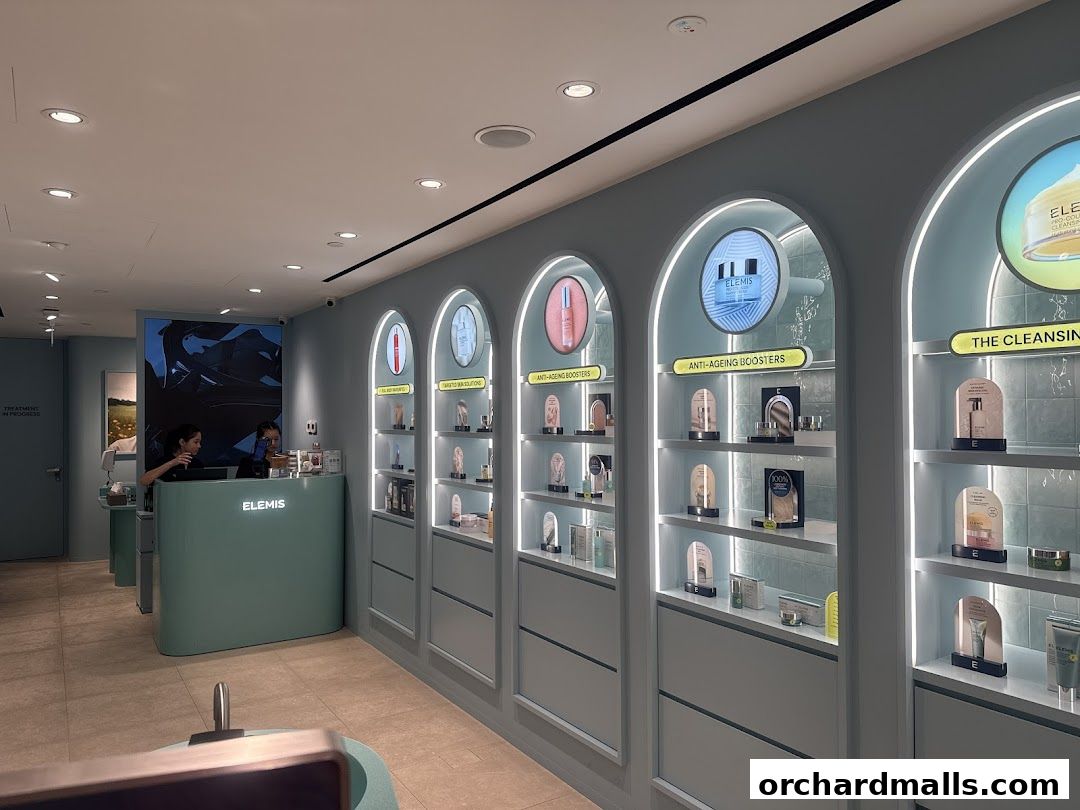 Interior of an Elemis London shop with skincare products displayed on shelves and a reception desk.