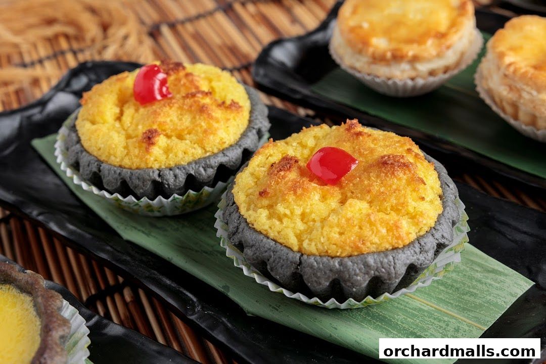 Close-up of two delicious Cantonese egg tarts with a cherry on top.