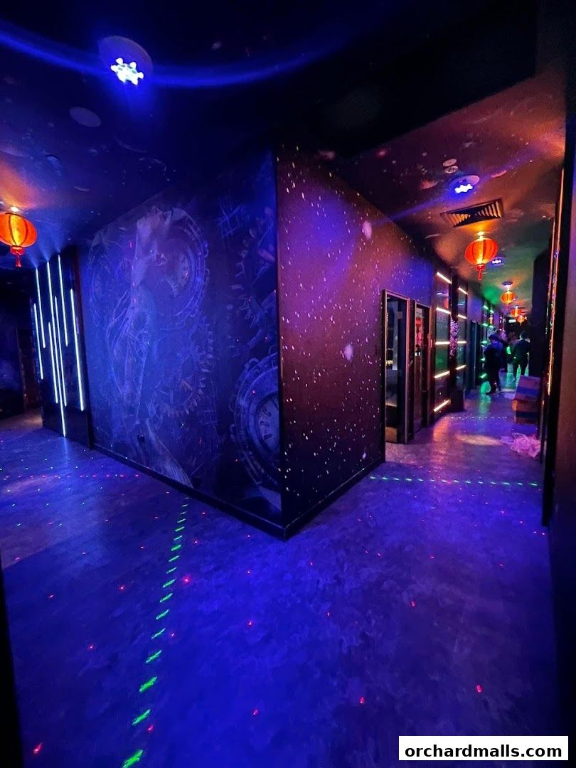 A dimly lit hallway with neon lights, starry wallpaper, and glowing floor patterns.