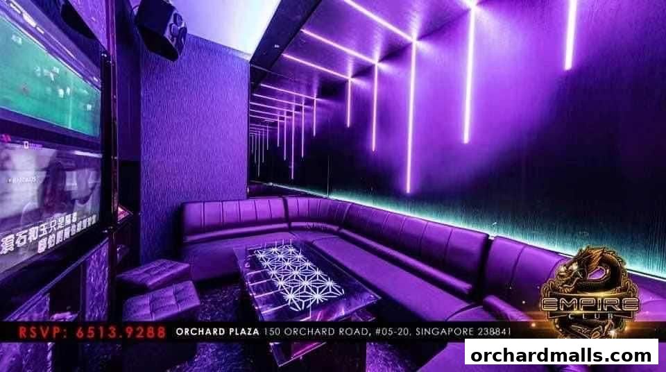 A luxurious KTV room with purple seating, neon lights, and a large screen.