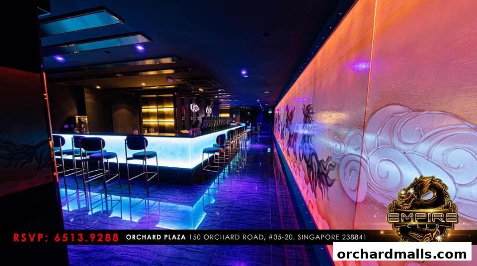 Interior of Empire KTV with a bar, seating, and illuminated walls.