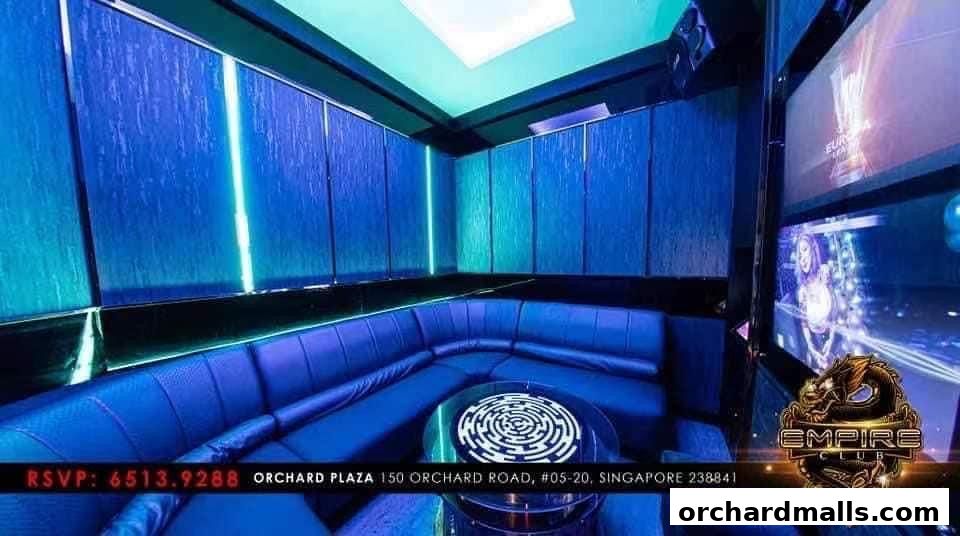 Luxurious KTV room with blue LED lighting, plush seating, and screens.