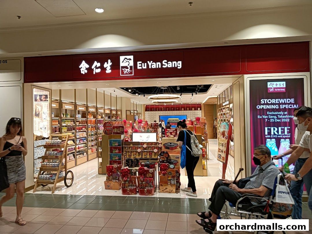 Eu Yan Sang shop front with promotional display and customers.
