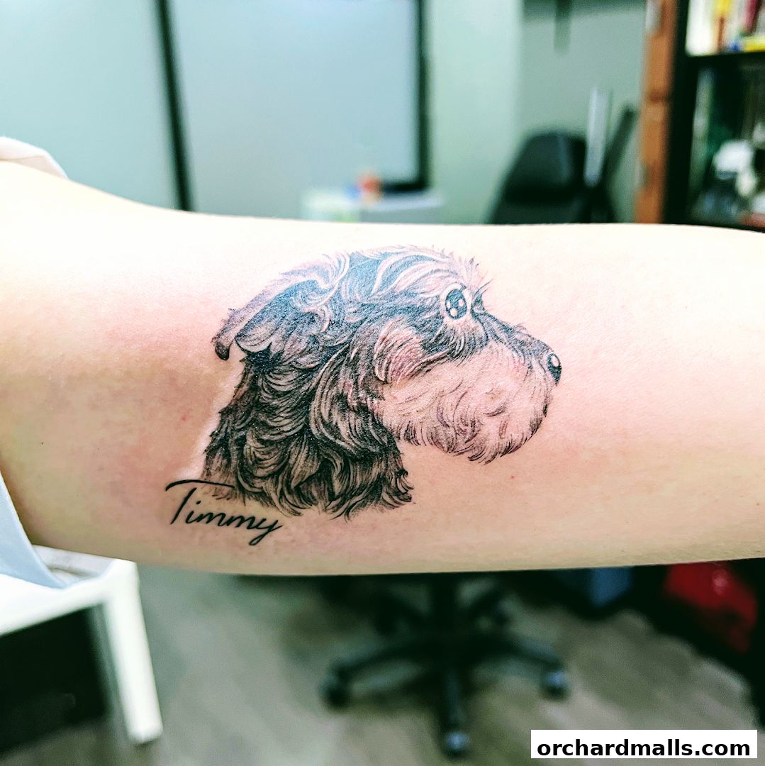 A realistic tattoo of a dog's head with the name 'Timmy' below it on an arm.