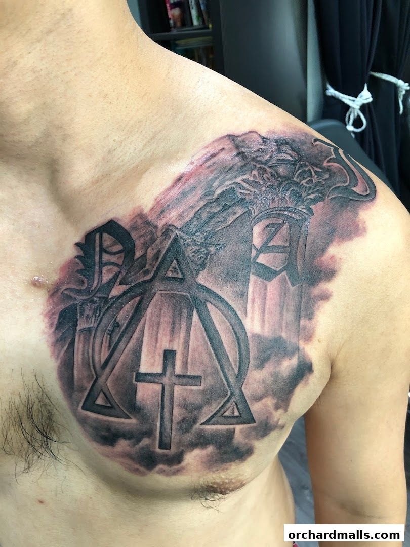 A detailed tattoo of a Chi Rho symbol with a cross on a person's chest.