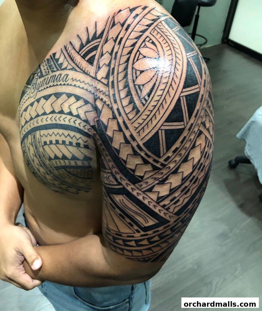 A person displays a detailed black tribal tattoo covering their shoulder and chest.